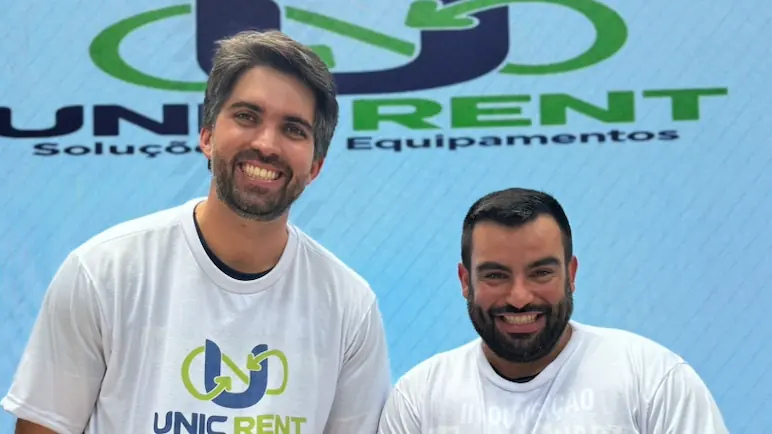 Diretores da Unic Rent diante do painel com o novo logotipo da marca